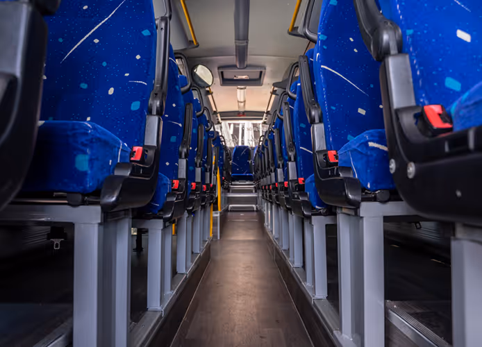 Przestronne wnętrze autobusu Iveco Crossway z rzędami wygodnych foteli, zapewniające komfort pasażerom na trasach regionalnych.