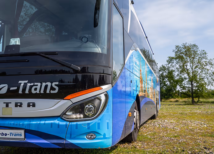Przód flagowego autokaru turystycznego Setra S517 "Baba Jaga", dostępnego na wynajem we Wrocławiu, zaparkowany w malowniczym miejscu.