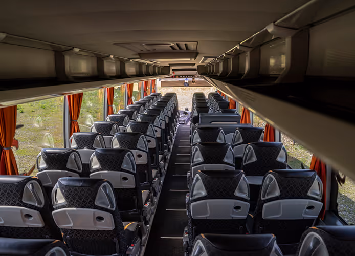 Obszerne i luksusowe wnętrze flagowego autokaru turystycznego Setra S517, gotowe na długie i komfortowe podróże po Europie.