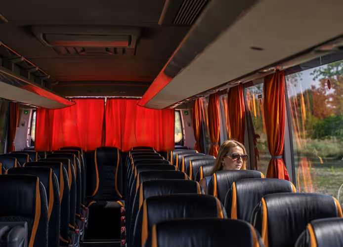 Pasażerka relaksująca się w wygodnym fotelu autokaru Setra, co symbolizuje komfort i przyjemność wycieczek autokarowych z Turbo-Trans.