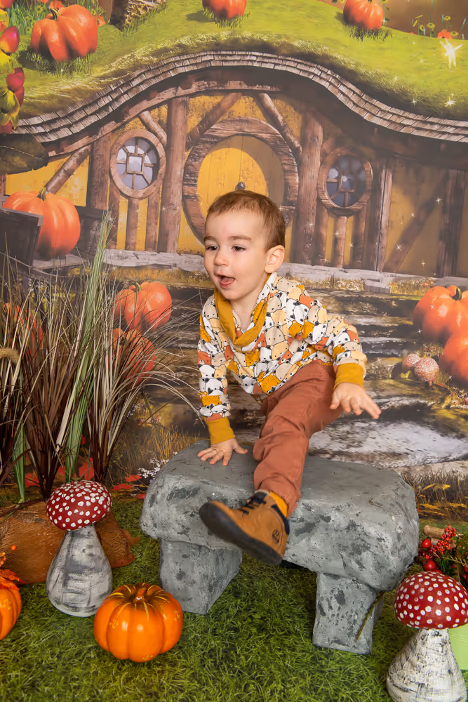 Kind bei einer herbstlichen Kita-Fotoaktion mit Kürbis-Dekoration