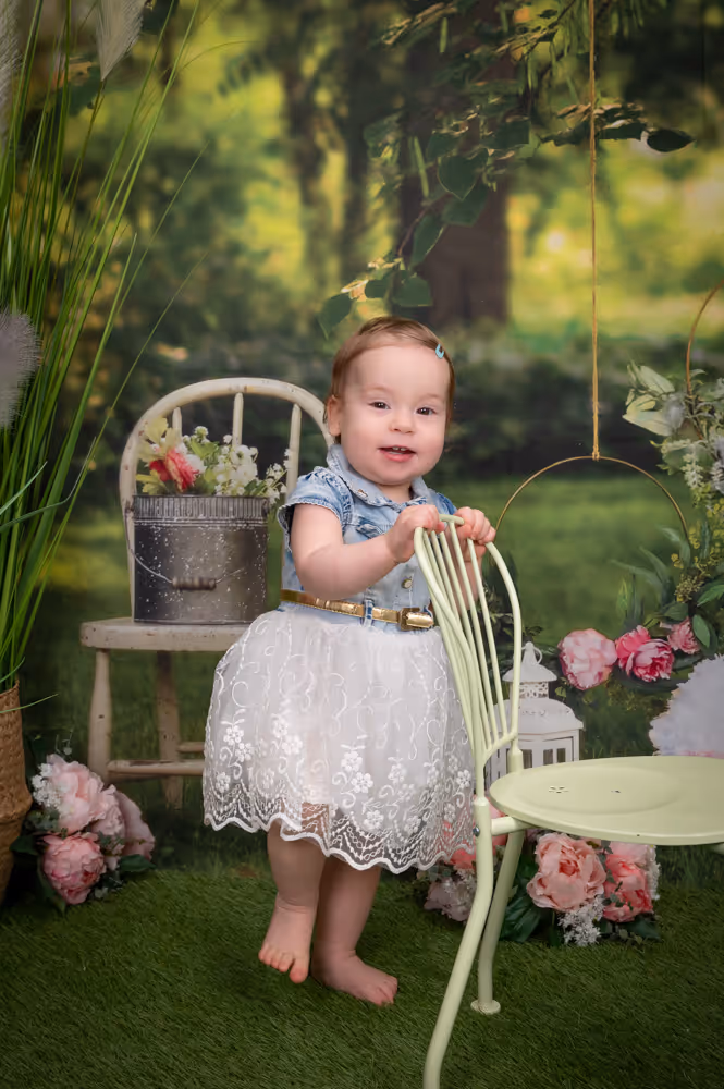 Kleinkind bei einer Kita-Fotoaktion vor einem Frühlings-Motivhintergrund