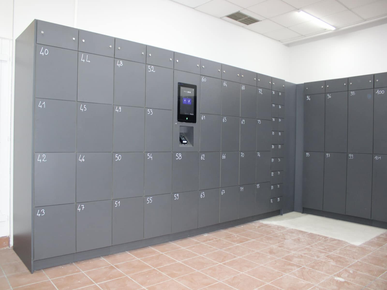 Public-space locker bank for temporary paid bag storage
