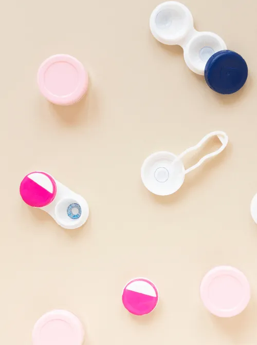 Contact lens cases and containers in pink, white, and blue colors