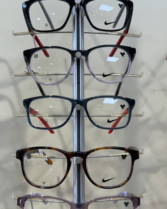 Nike eyeglasses displayed on a vertical stand in various colors and styles
