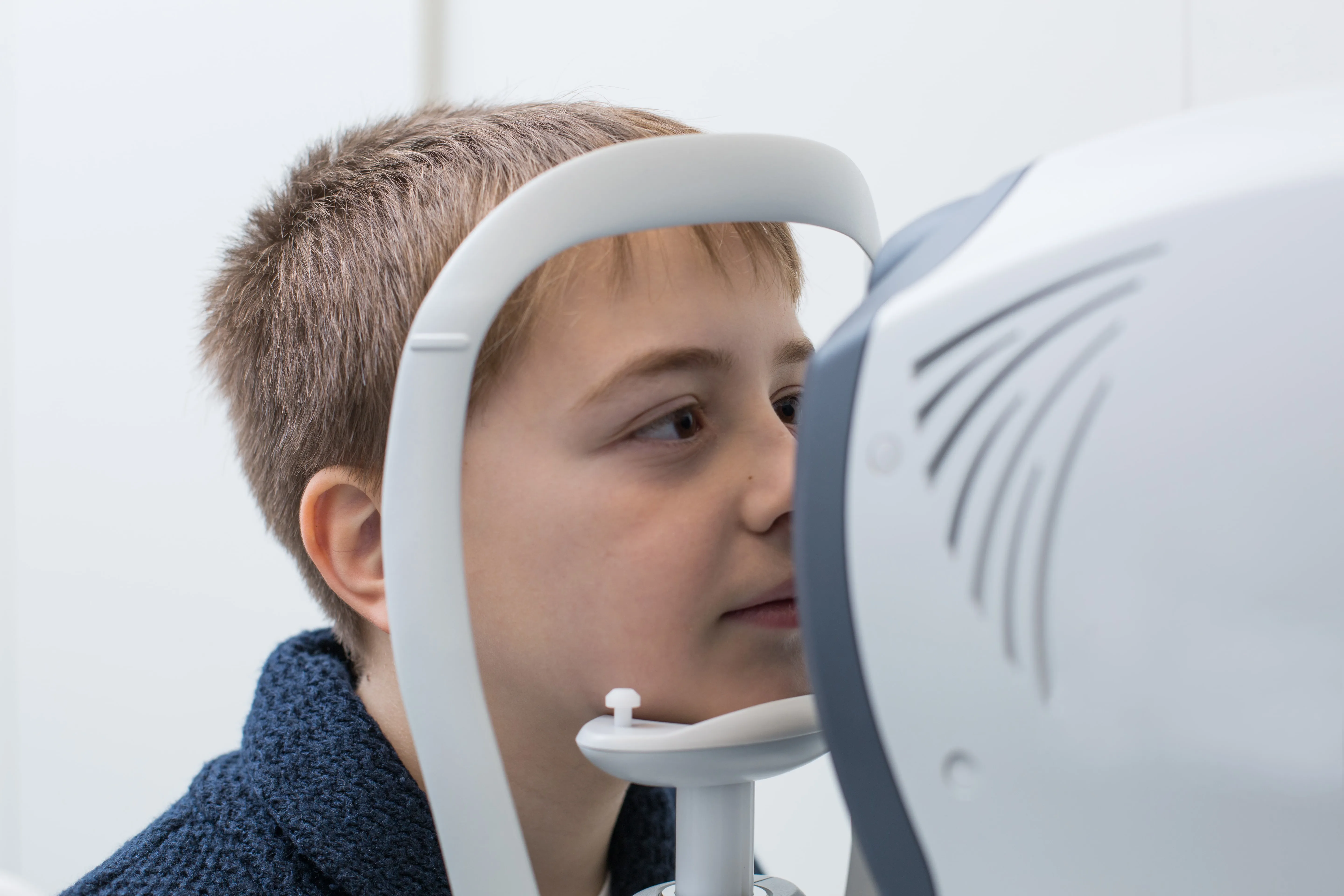 Child having eye exam with professional medical equipment