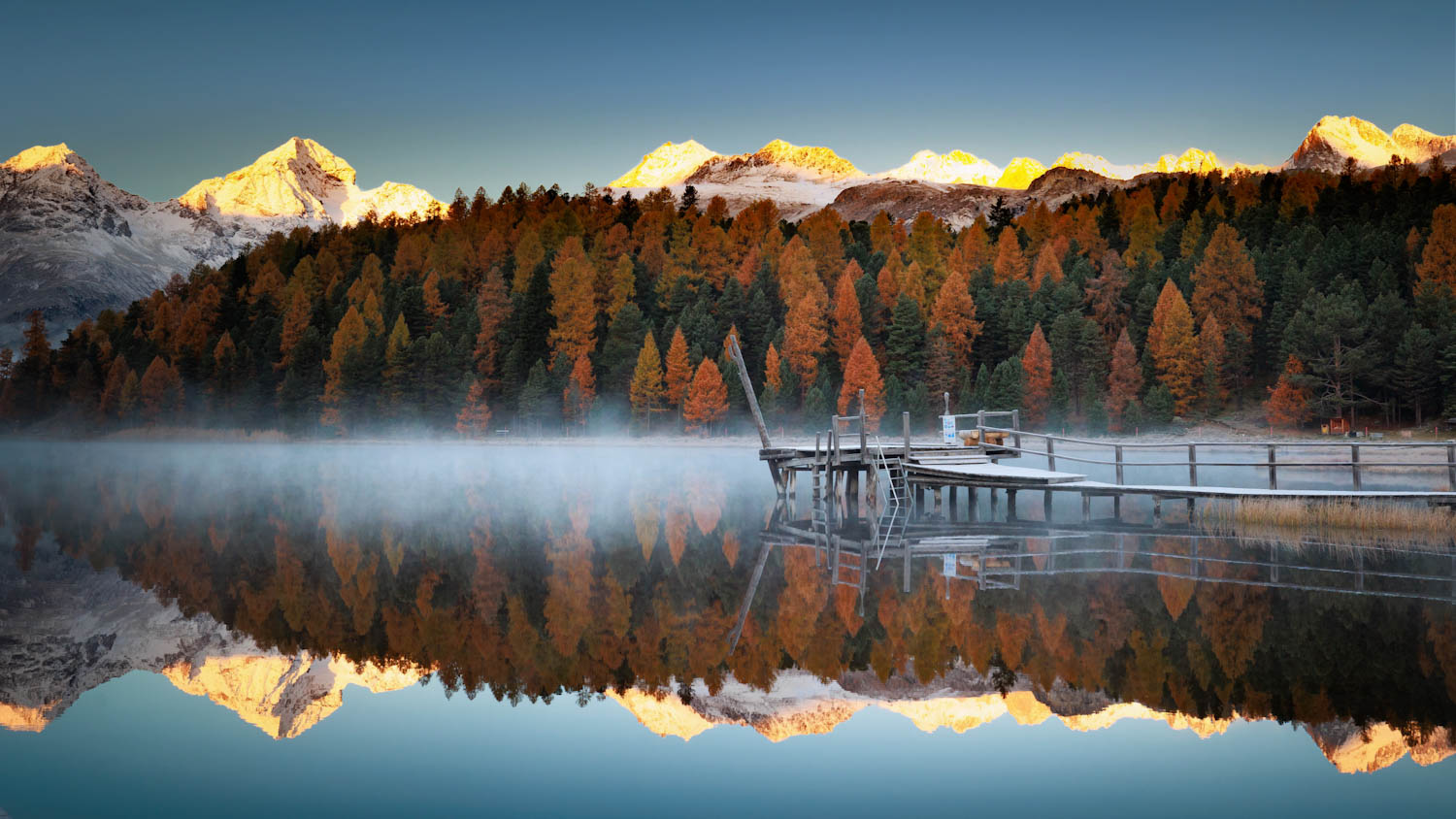 Stazersee mit Bootsstg im Herbstnebel über dem Wasser