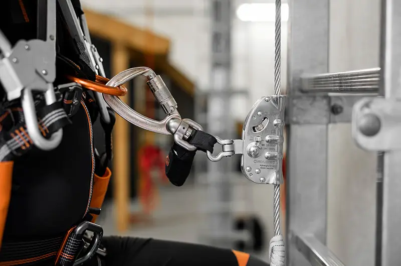 Worker connected to a Skylotec vertical lifeline system using a guided fall arrester for safe work at height
