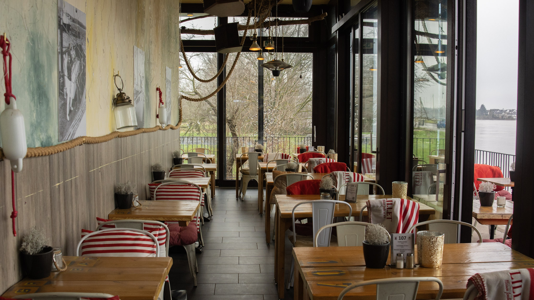 Innenaufnahme des Restaurants Graubi in Bonn mit Blick auf den Rhein – warme Lichtstimmung und maritime Dekoration, fotografiert von L’Étoile Visuals