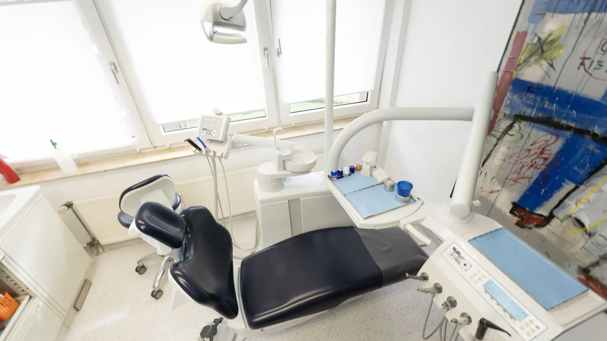 Moderner Behandlungsstuhl in einer hellen Zahnarztpraxis mit Kunst an der Wand. LetVis Media