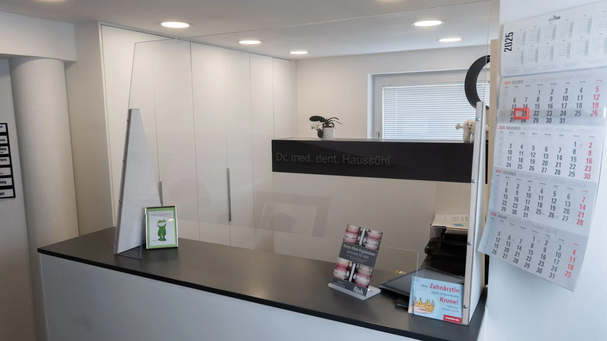Rezeption der Zahnarztpraxis Dr. Haussühl mit modernem Design, Broschüren und Kalender.