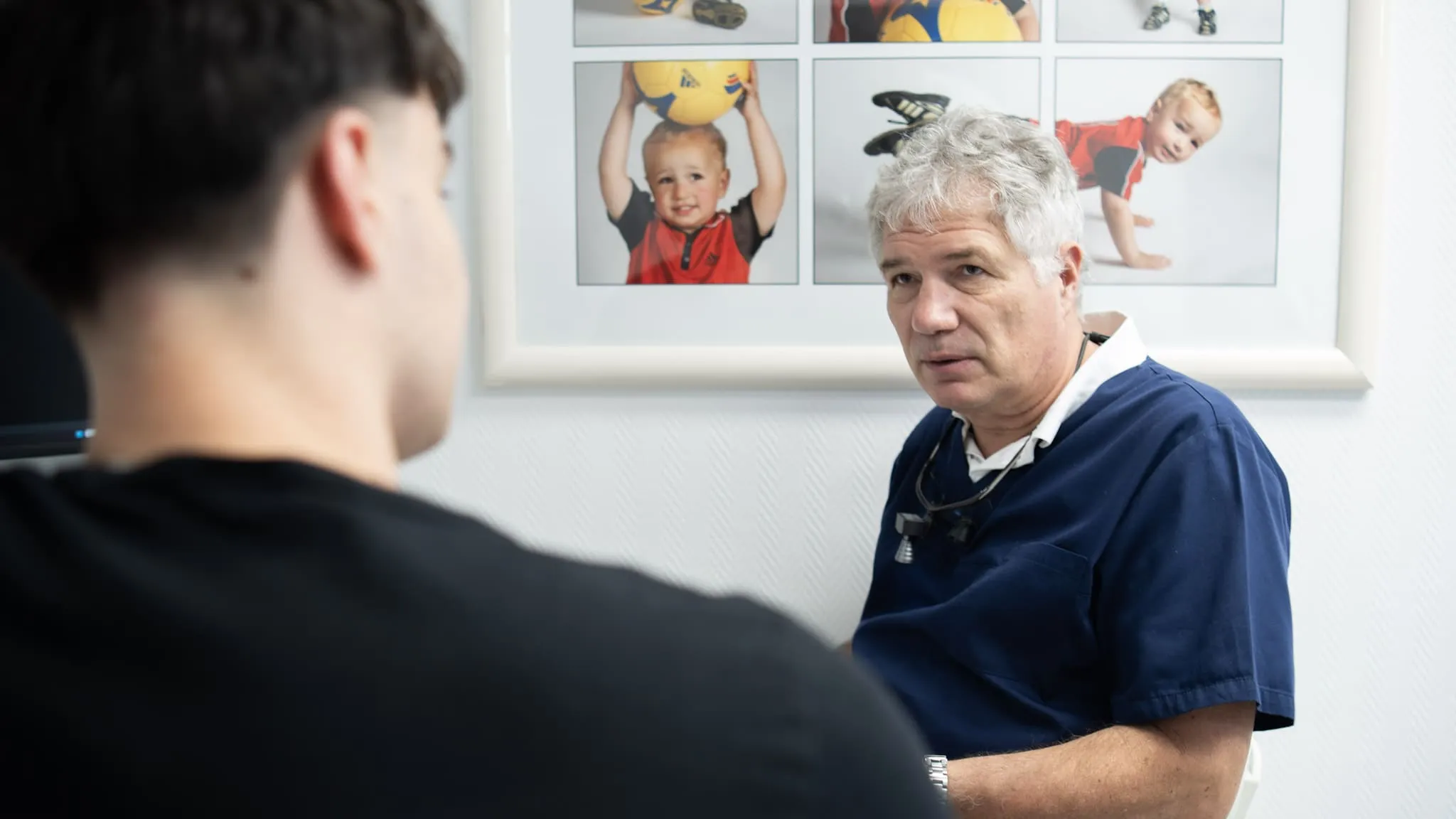 Zahnarzt im Gespräch mit einem Patienten über Behandlungsergebnisse in der Praxis.