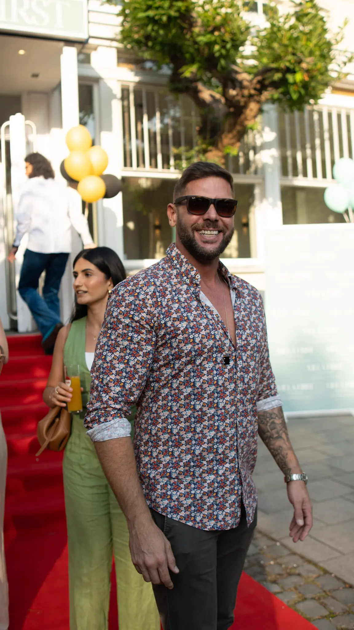 Mann mit Sonnenbrille begrüßt Gäste auf dem roten Teppich bei einem Sommer-Event in Bonn – stilvolle Eventfotografie von L’Étoile Visuals