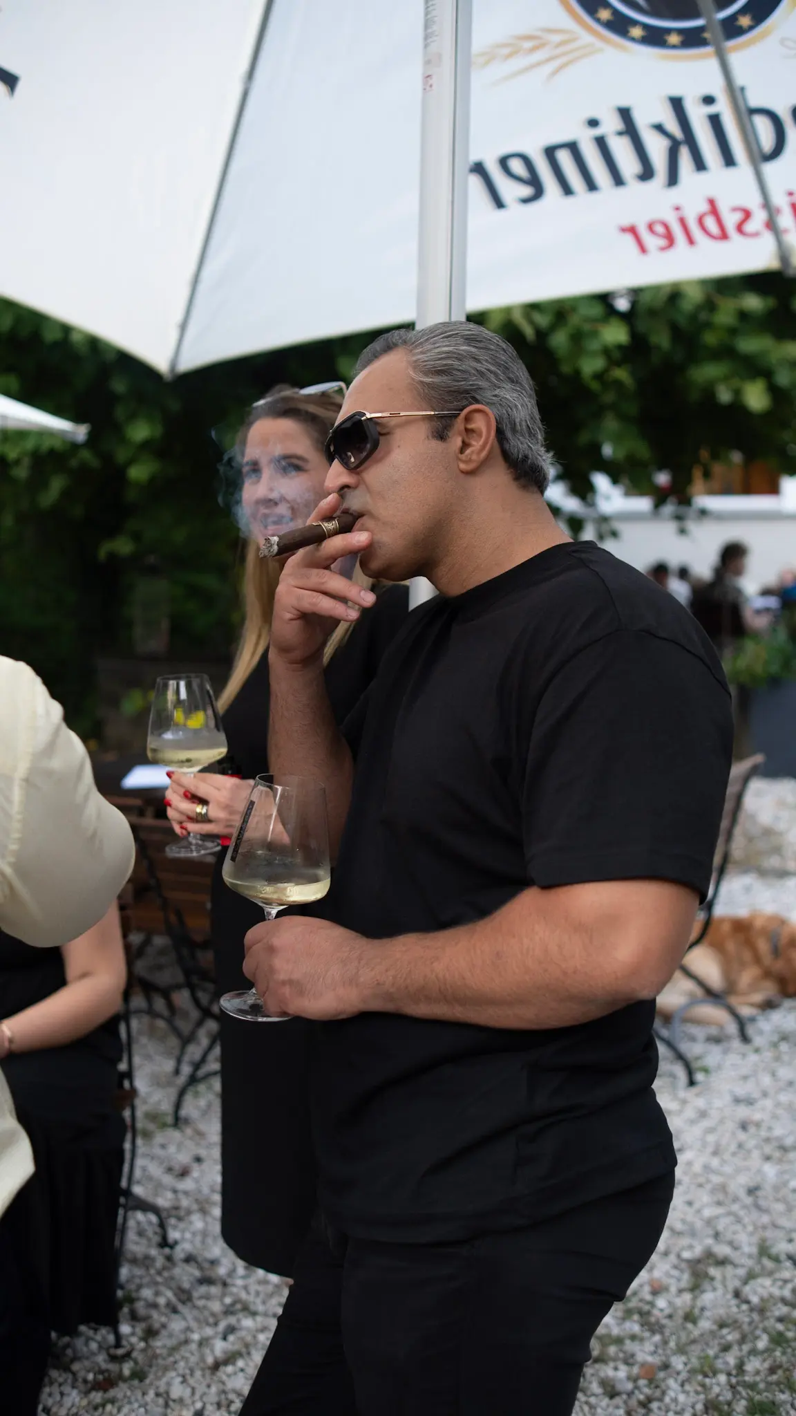 Gast mit Zigarre und Weißwein bei der Villa First Eröffnungsfeier – stilvolle und authentische Eventfotografie von L’Étoile Visuals