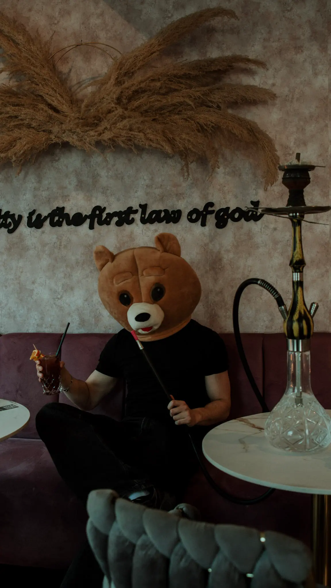 Person mit Tiermaske entspannt in Lounge mit Shisha und Drink – kreative Eventfotografie im Café-Ambiente – L’Étoile Visuals
