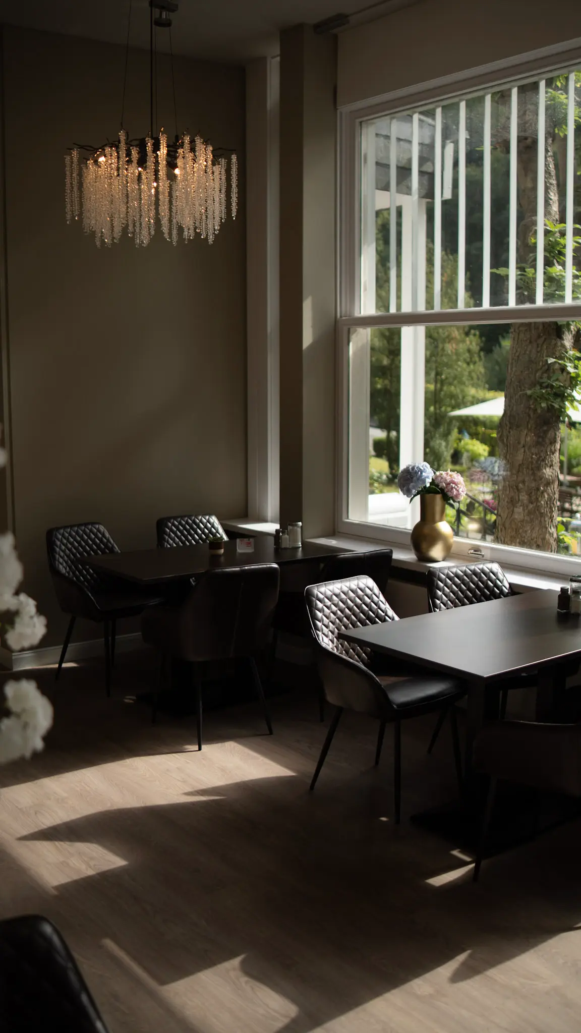 Stilvolles Restaurant-Interieur der Villa First mit modernen Sitzmöbeln, Lichteinfall durch große Fenster und Blumenvasen – fotografiert von L’Étoile Visuals
