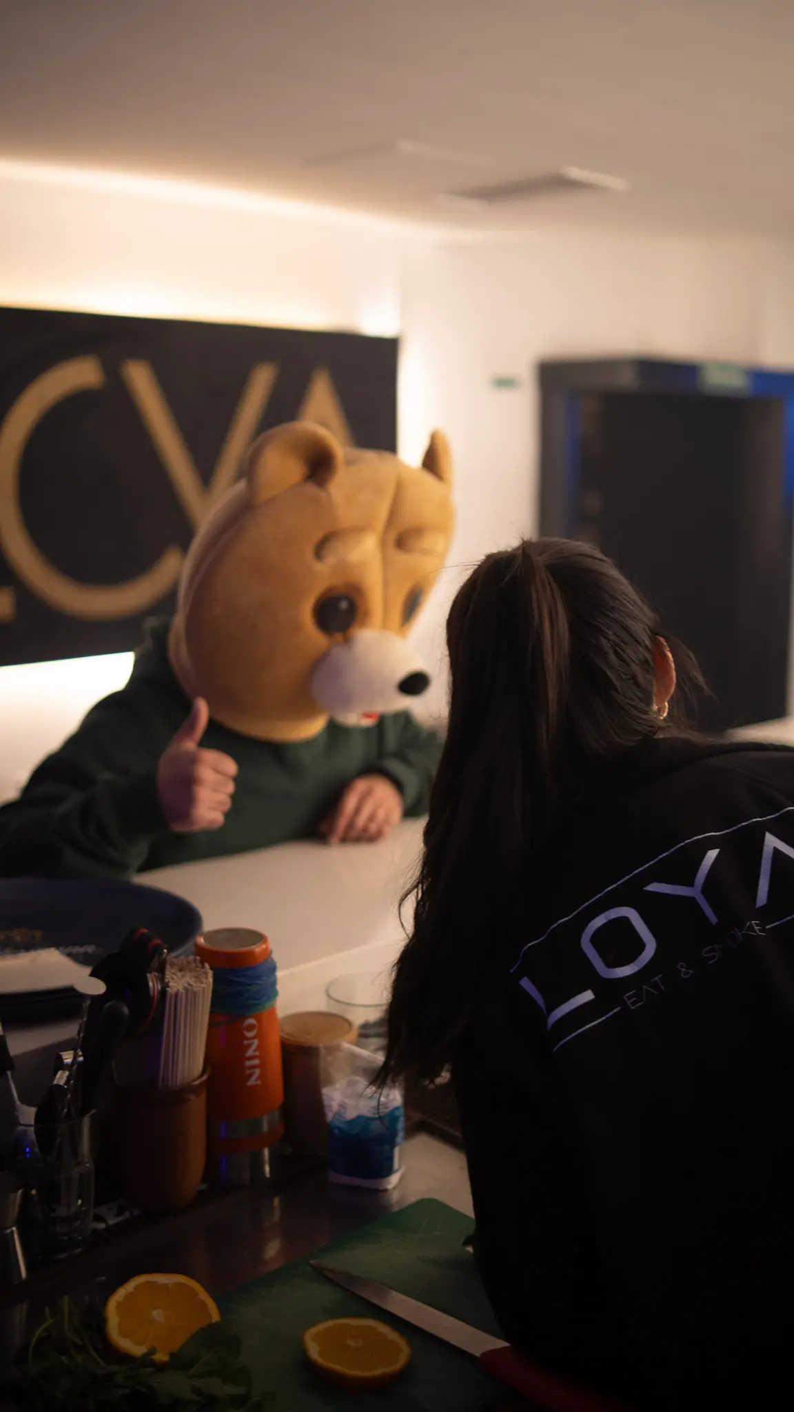 Maskottchen an der Theke in der Loyal Bar, interagiert mit Barkeeperin – authentische Gastronomie-Fotografie von LetVis Media