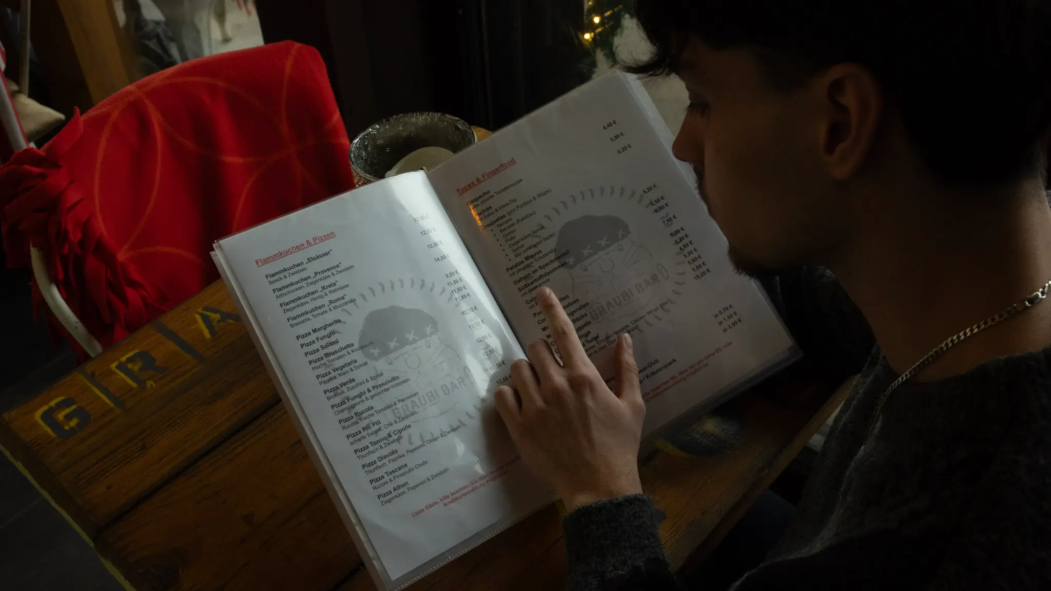 Gast blättert durch die Speisekarte der Graubi Bar – authentische Gastronomiefotografie von L’Étoile Visuals