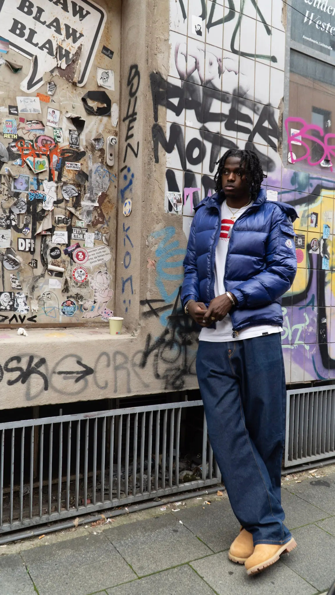 Urbanes Streetstyle-Fotoshooting – Model in blauer Jacke und Jeans steht vor Graffiti-Wand, fotografiert von L’Étoile Visuals