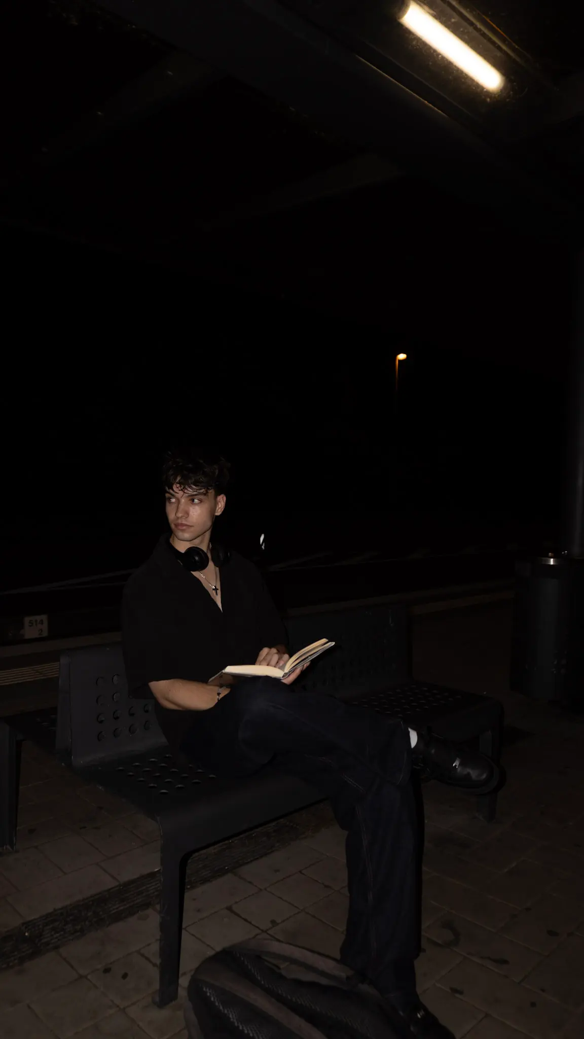 Natürliches Lifestyle-Porträt eines jungen Mannes im weißen Hemd auf einem Parkhausdach, lächelnd in die Kamera, fotografiert von L’Étoile Visuals