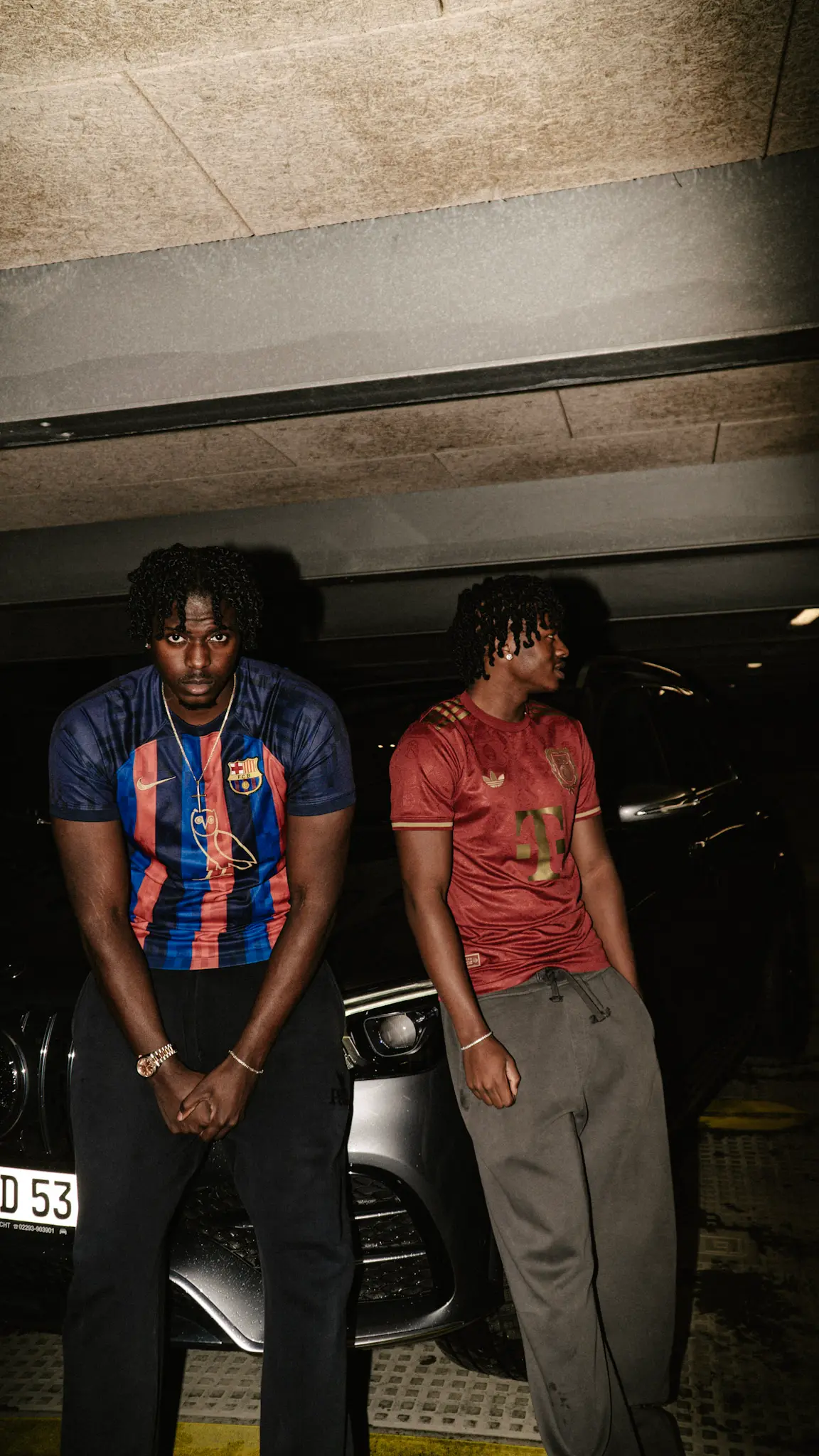 Urbanes Lifestyle-Fotoshooting – zwei Models in Fußballtrikots posieren im Parkhaus vor einem Auto, fotografiert von L’Étoile Visuals