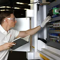 Um engenheiro da Evotec verificando a parte eletrônica e fazendo anotações em sua ficha de registro