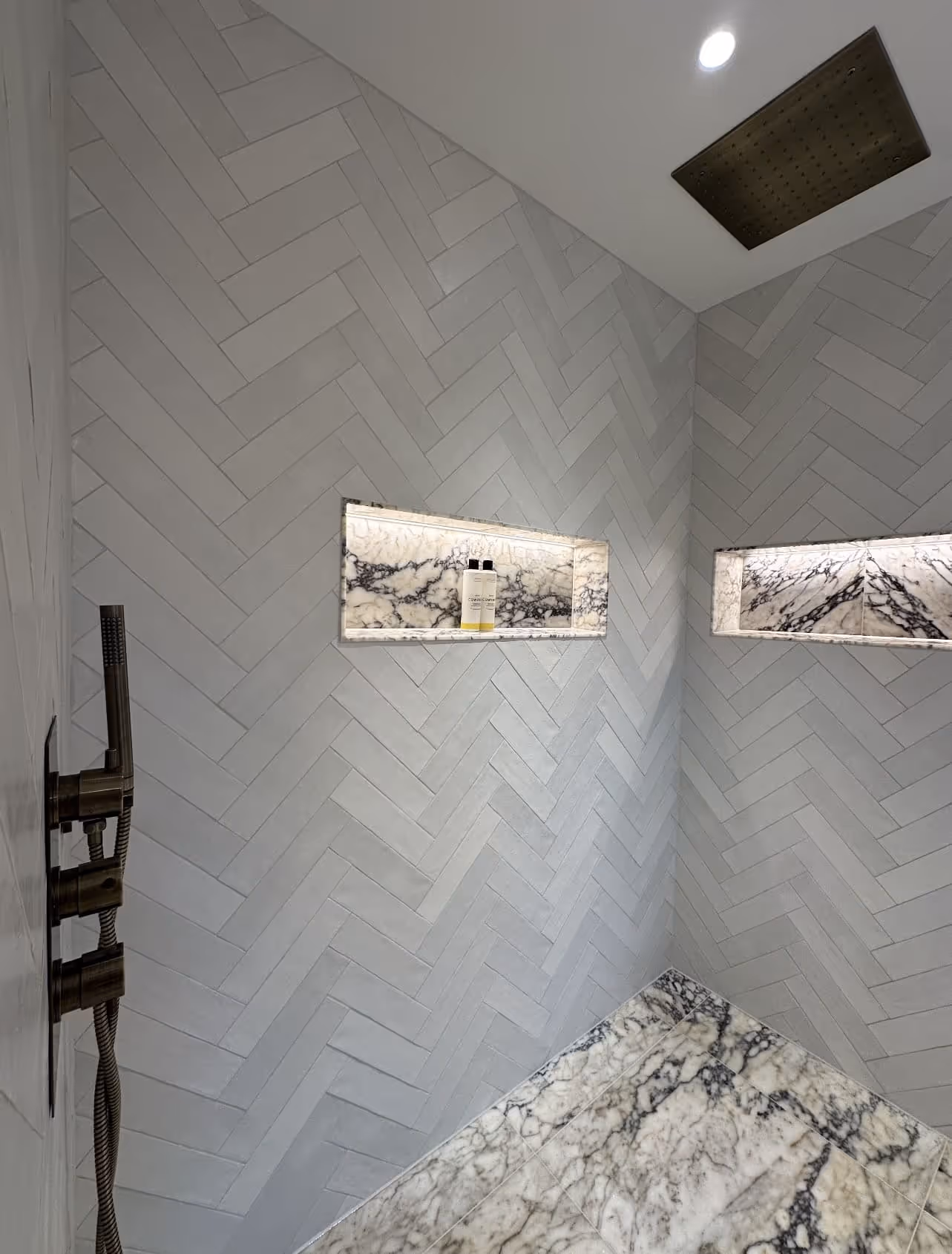 Contemporary walk-in shower with grey herringbone tiles