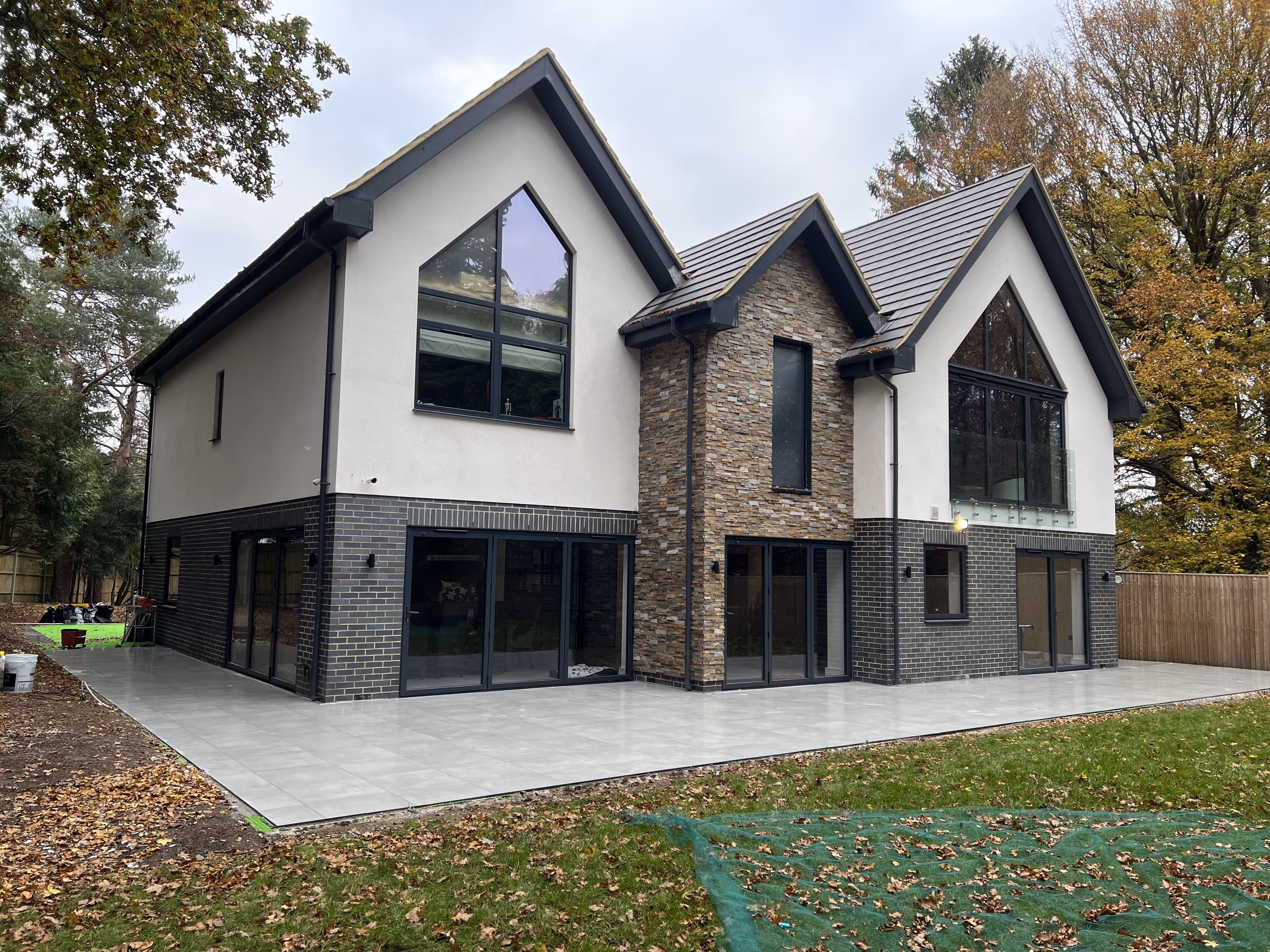 Luxury home with tiled outdoor floors and landscaped surroundings