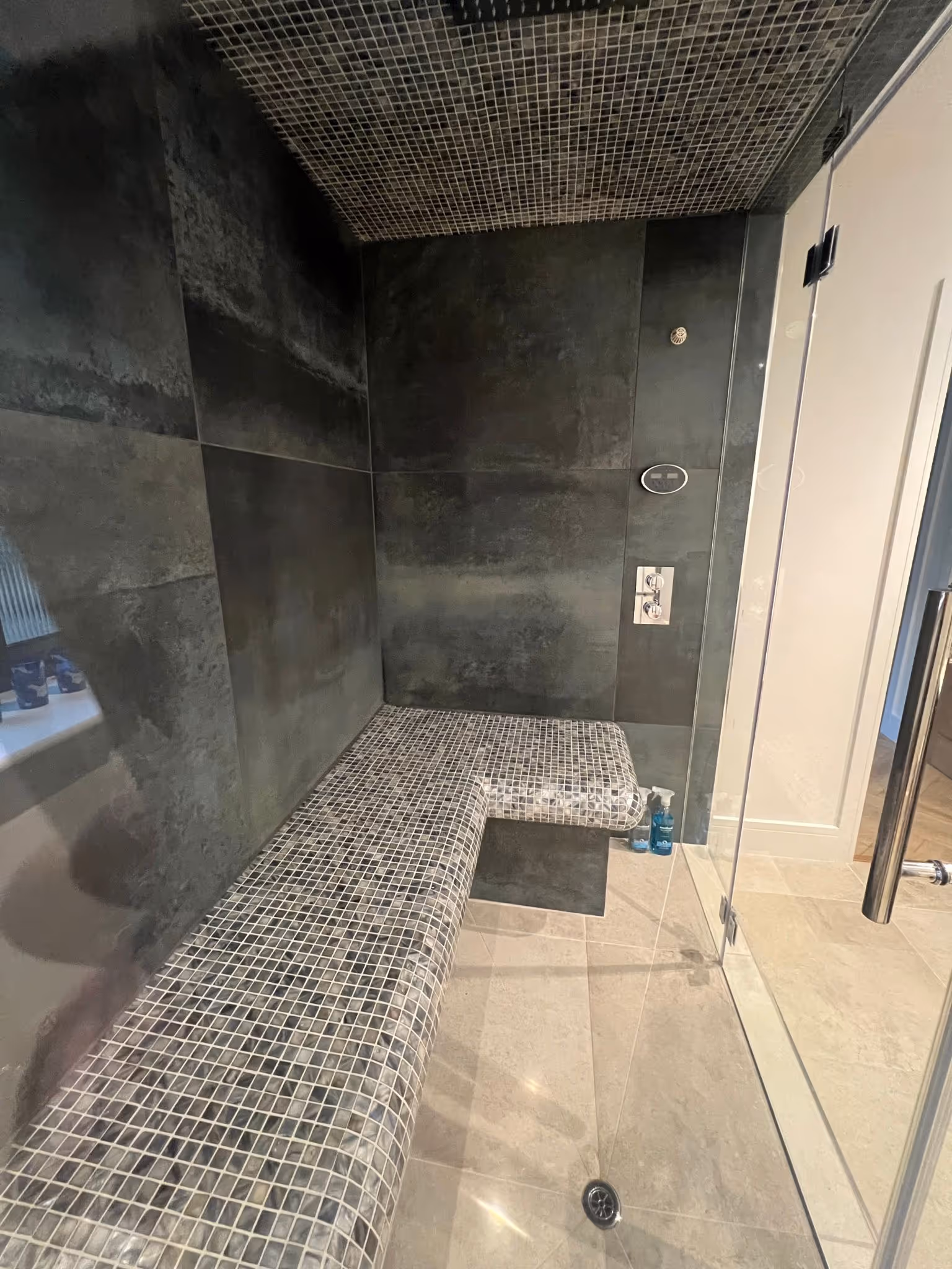 Black tiled walls with unique patterned seats