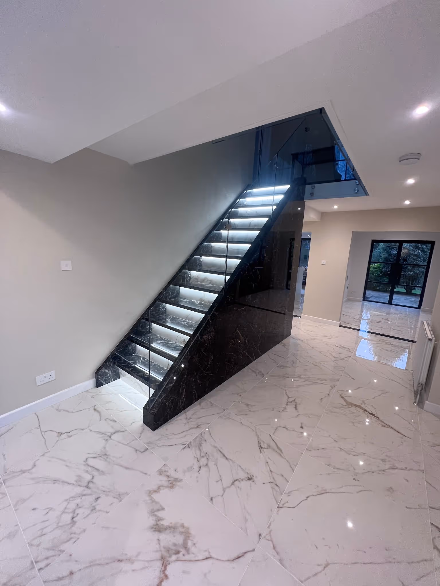 Elegant interior with marble floor tiles and sleek black staircase