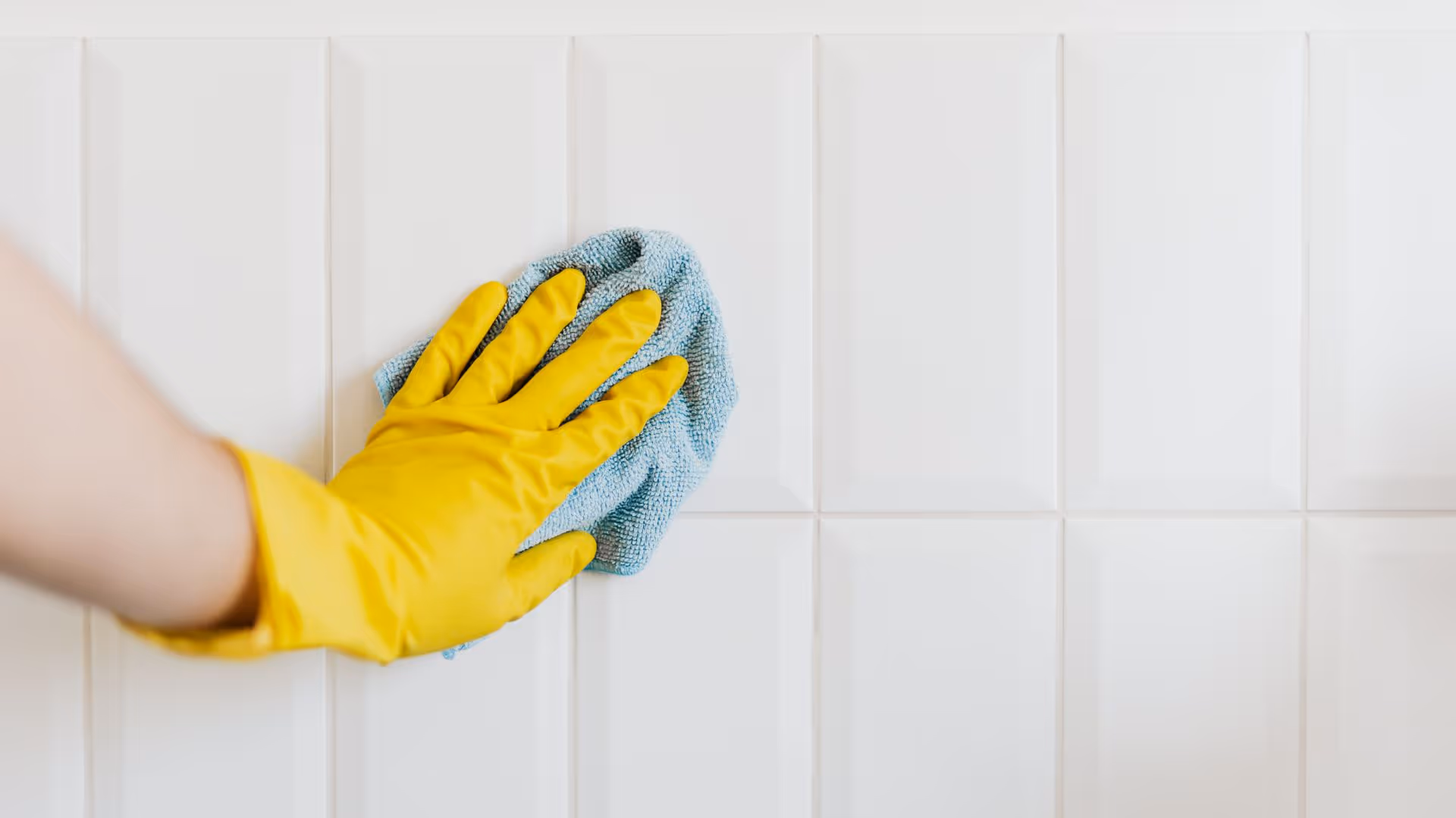 Modern bathroom with marble styled wall tiles and black tiling underneath bath