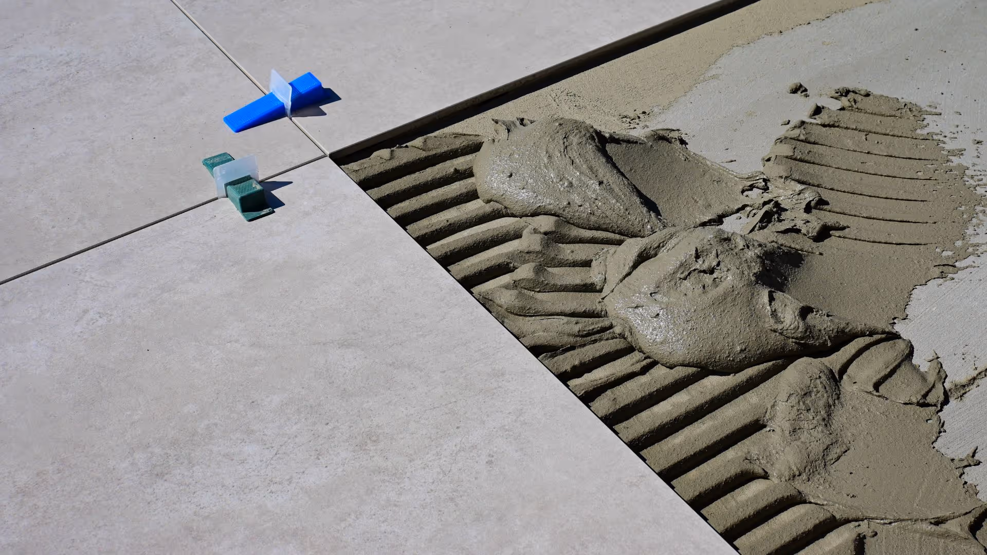 Modern bathroom with marble styled wall tiles and black tiling underneath bath