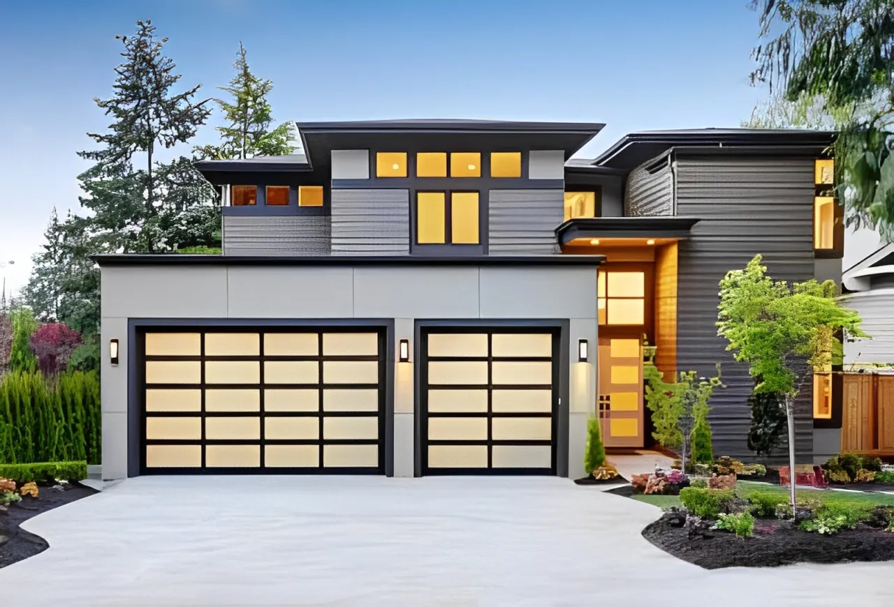 Modern two-story house with large glass-paneled garage doors and well-manicured landscaping.