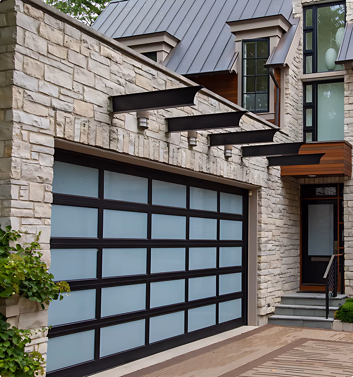 Modern house with a frosted glass and black frame garage door set in a stone exterior.