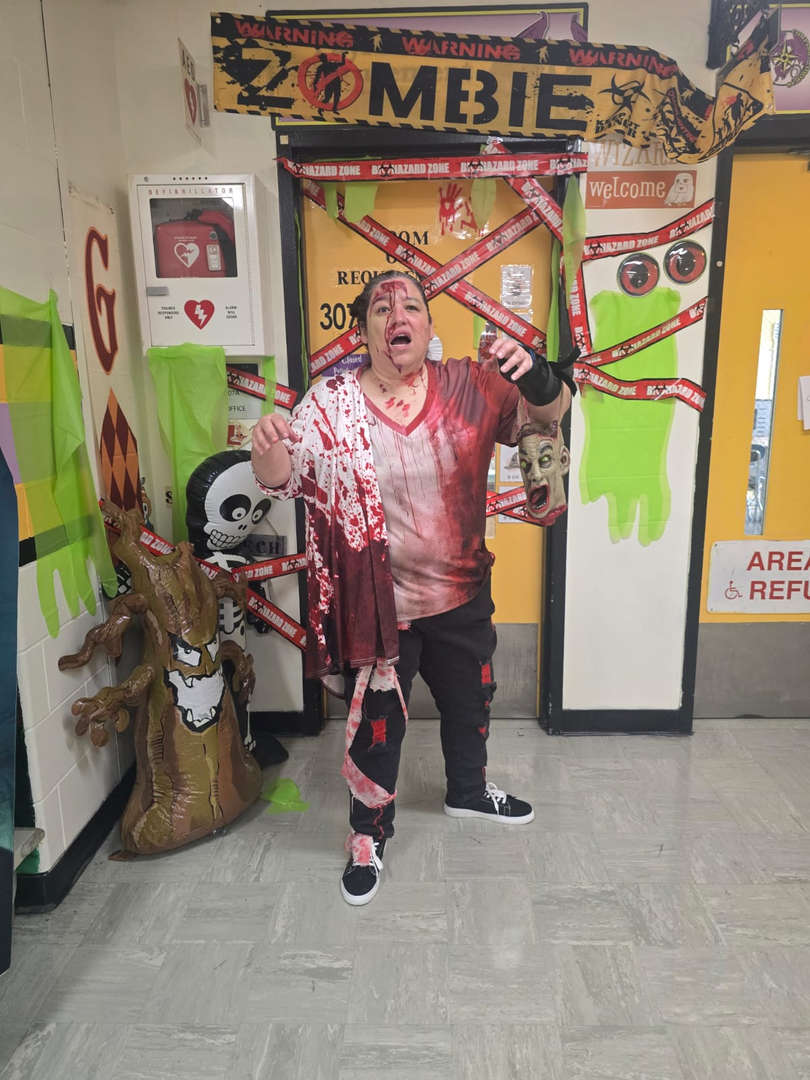 Student in a Halloween costume posing in a decorated hallway.