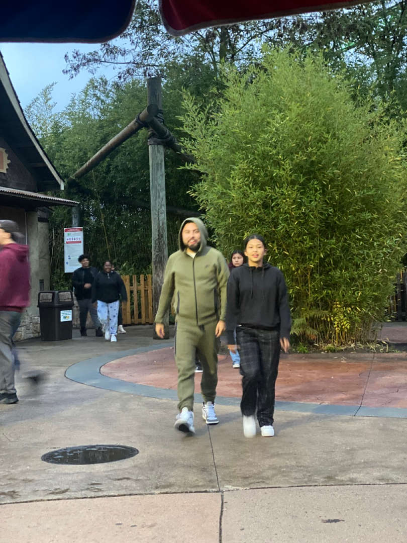 Two students walking outdoors on a pathway.
