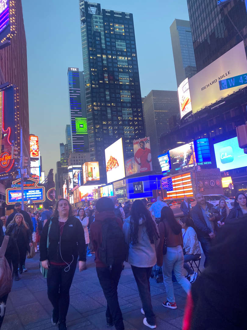 Students walking through a busy city street at night
