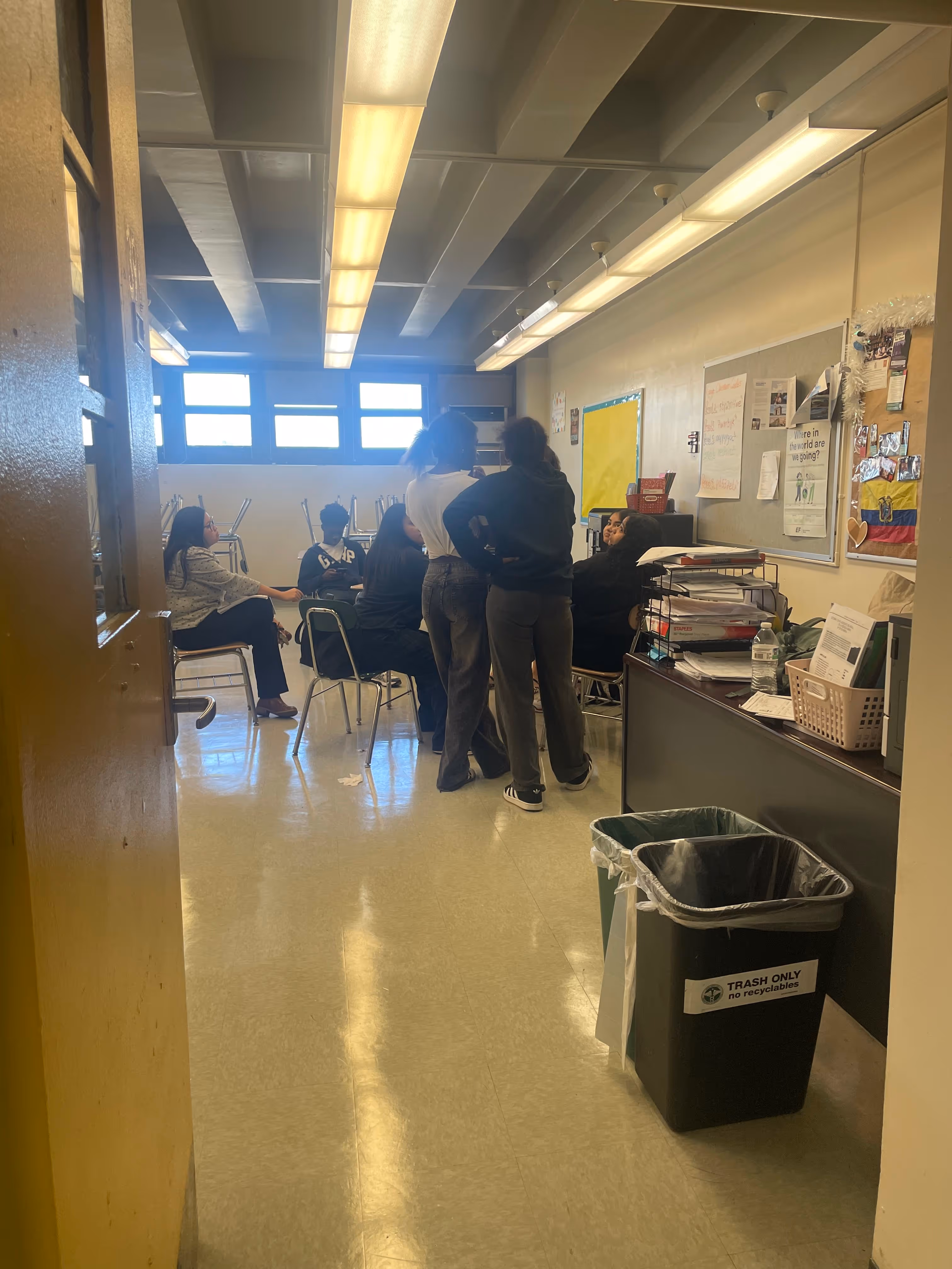 Students meeting in classroom with teacher standing