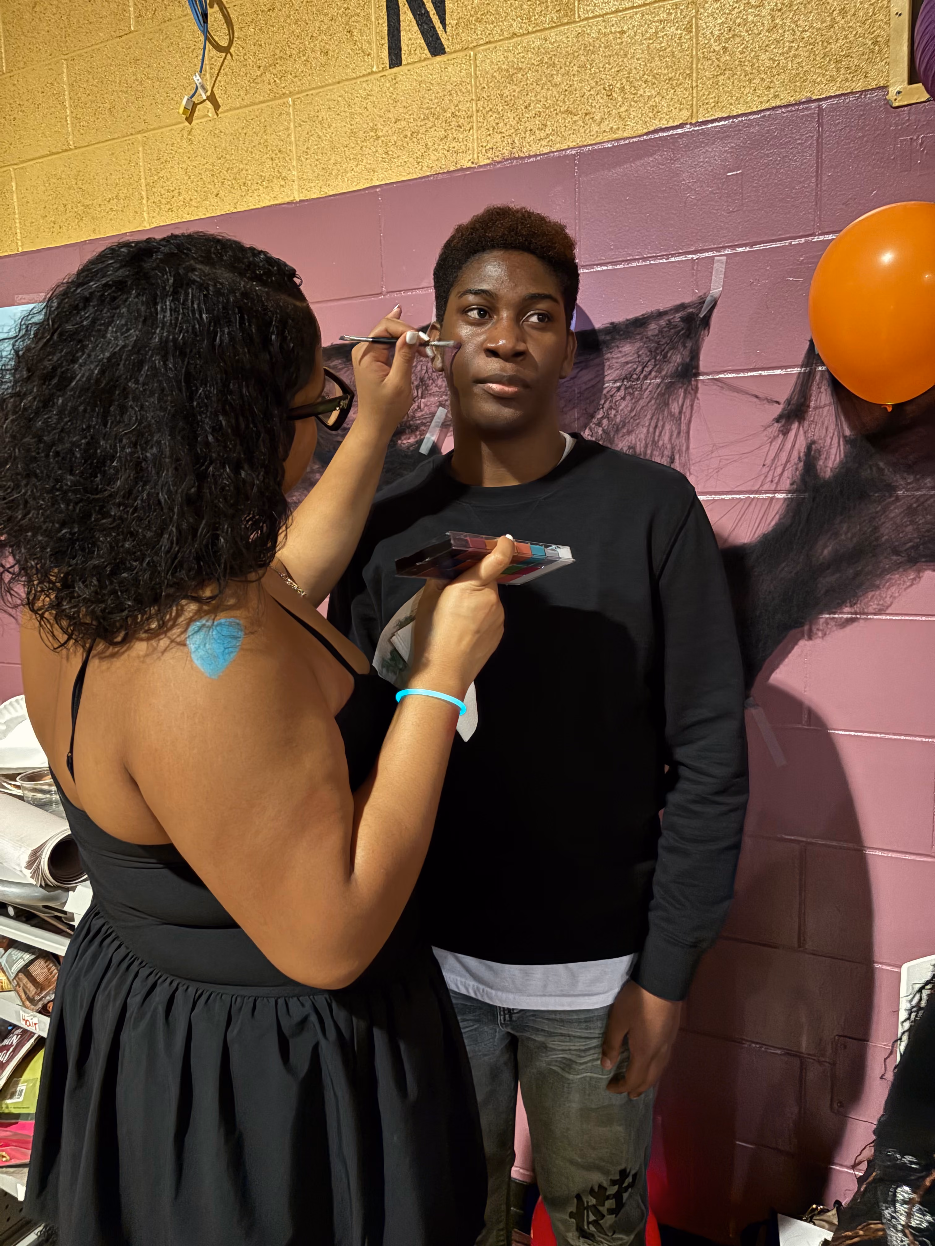 Student receives face painting at school event