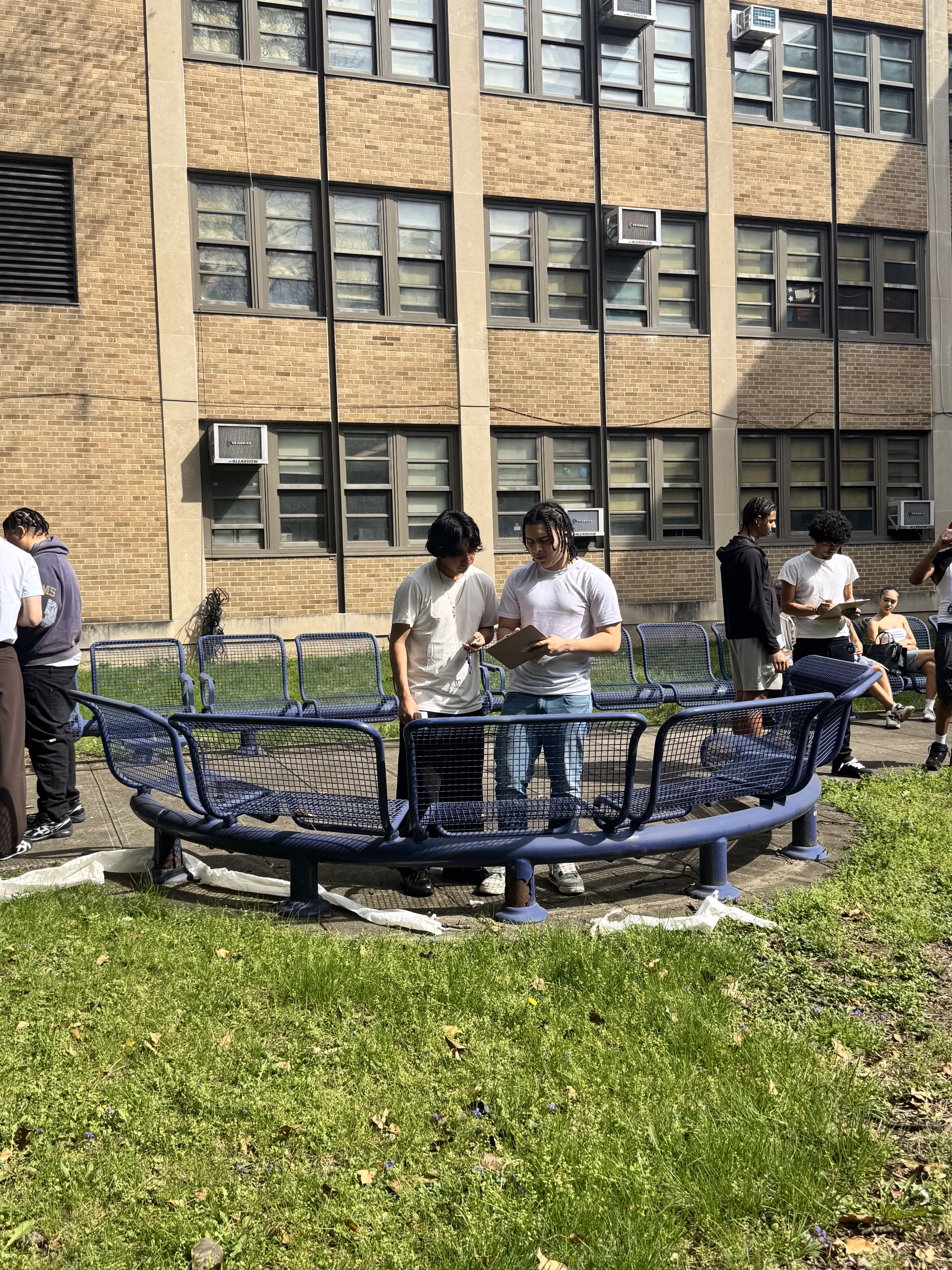 Students gathered around outdoor learning bench in schoolyard