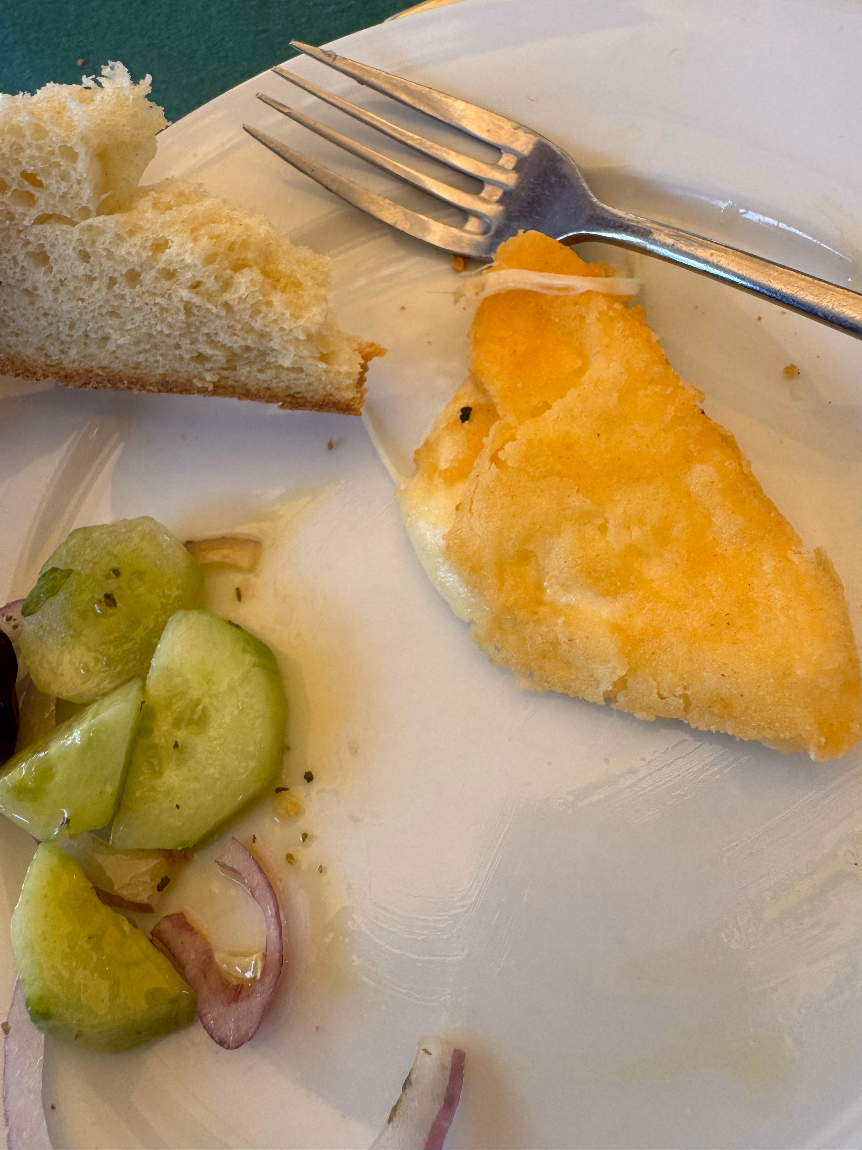 School lunch with breaded fish, bread, and cucumber salad