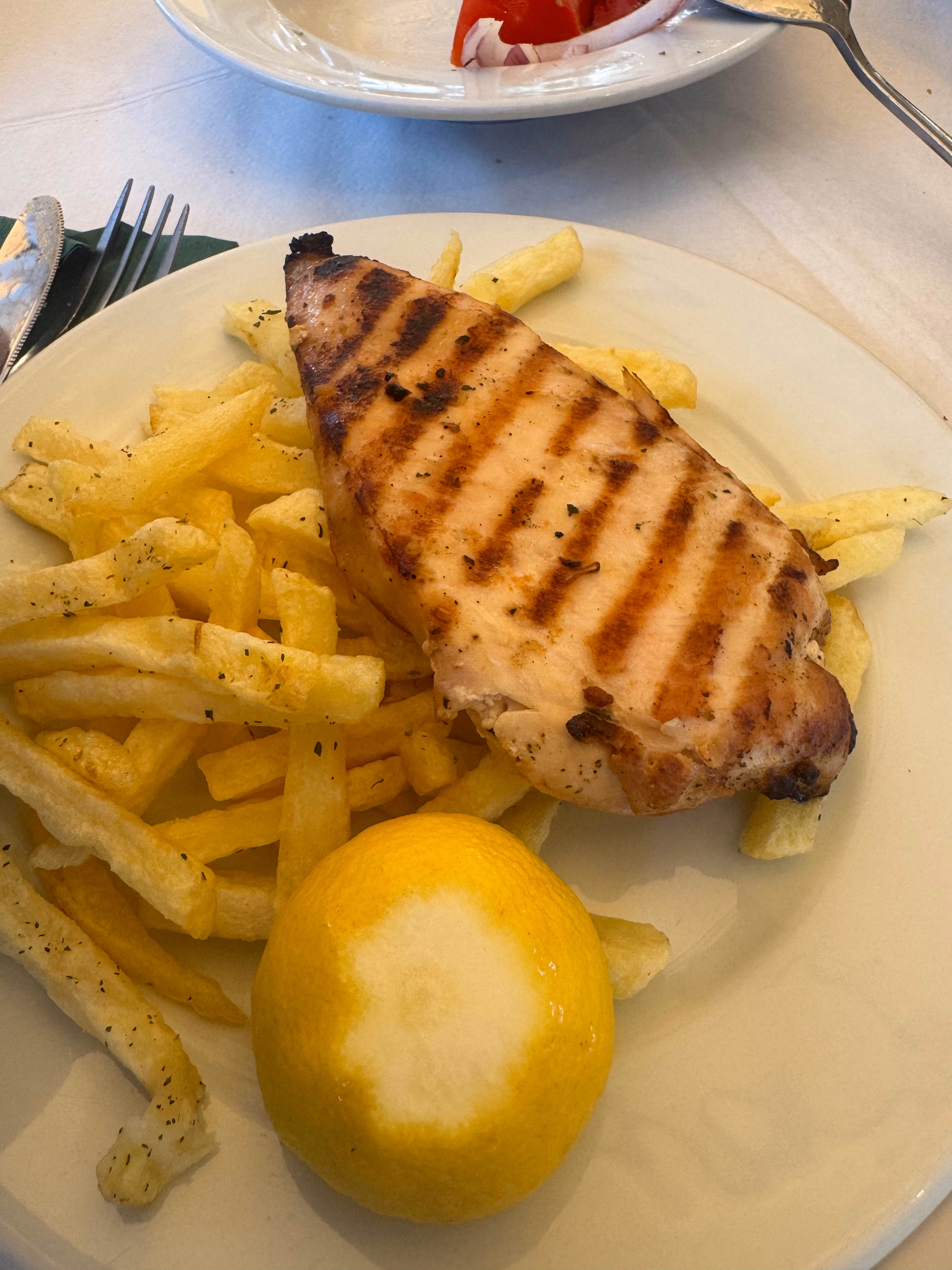 Grilled chicken breast with french fries and lemon