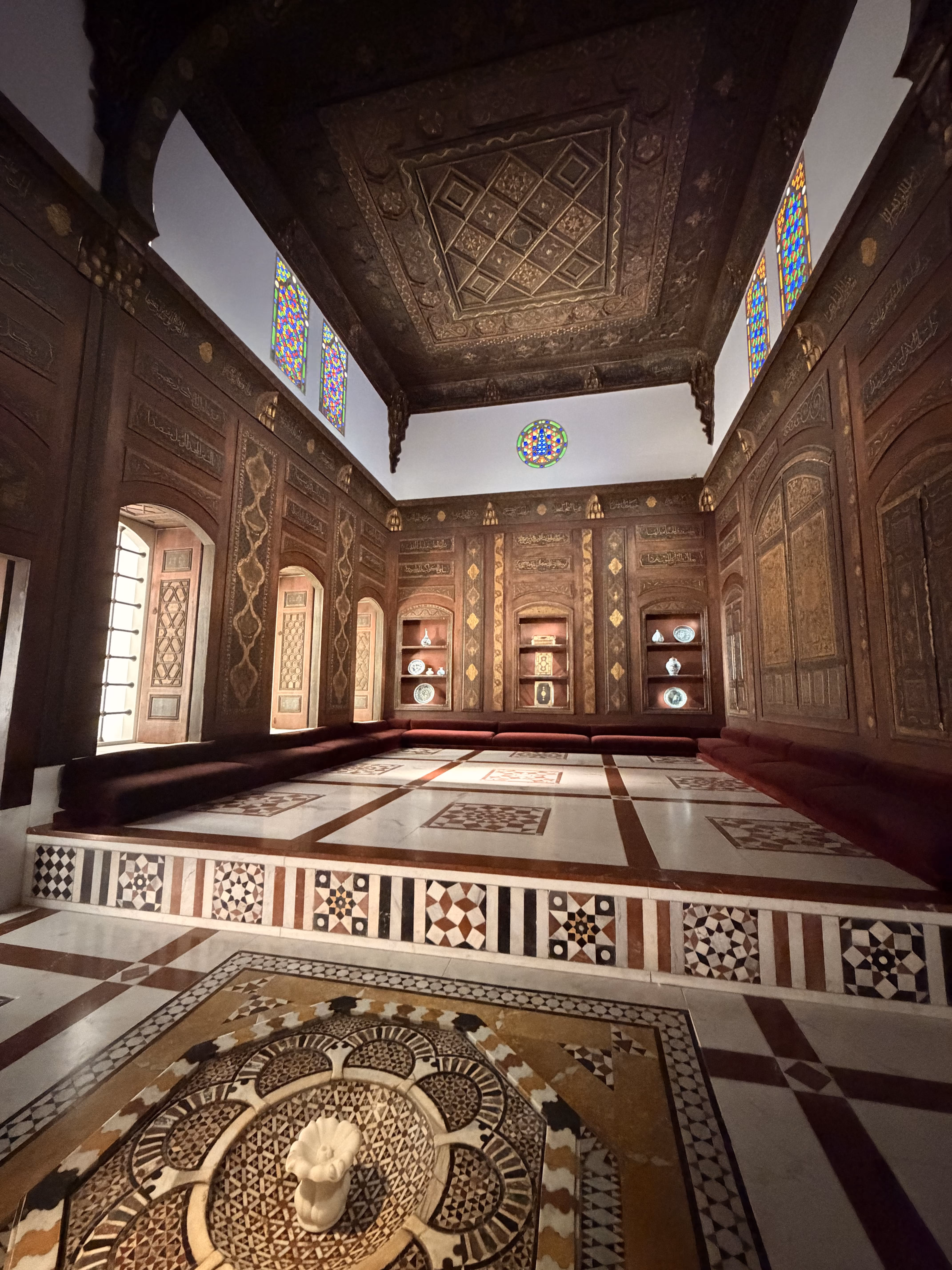 Historic room interior with ornate geometric wooden panels and mosaic floor