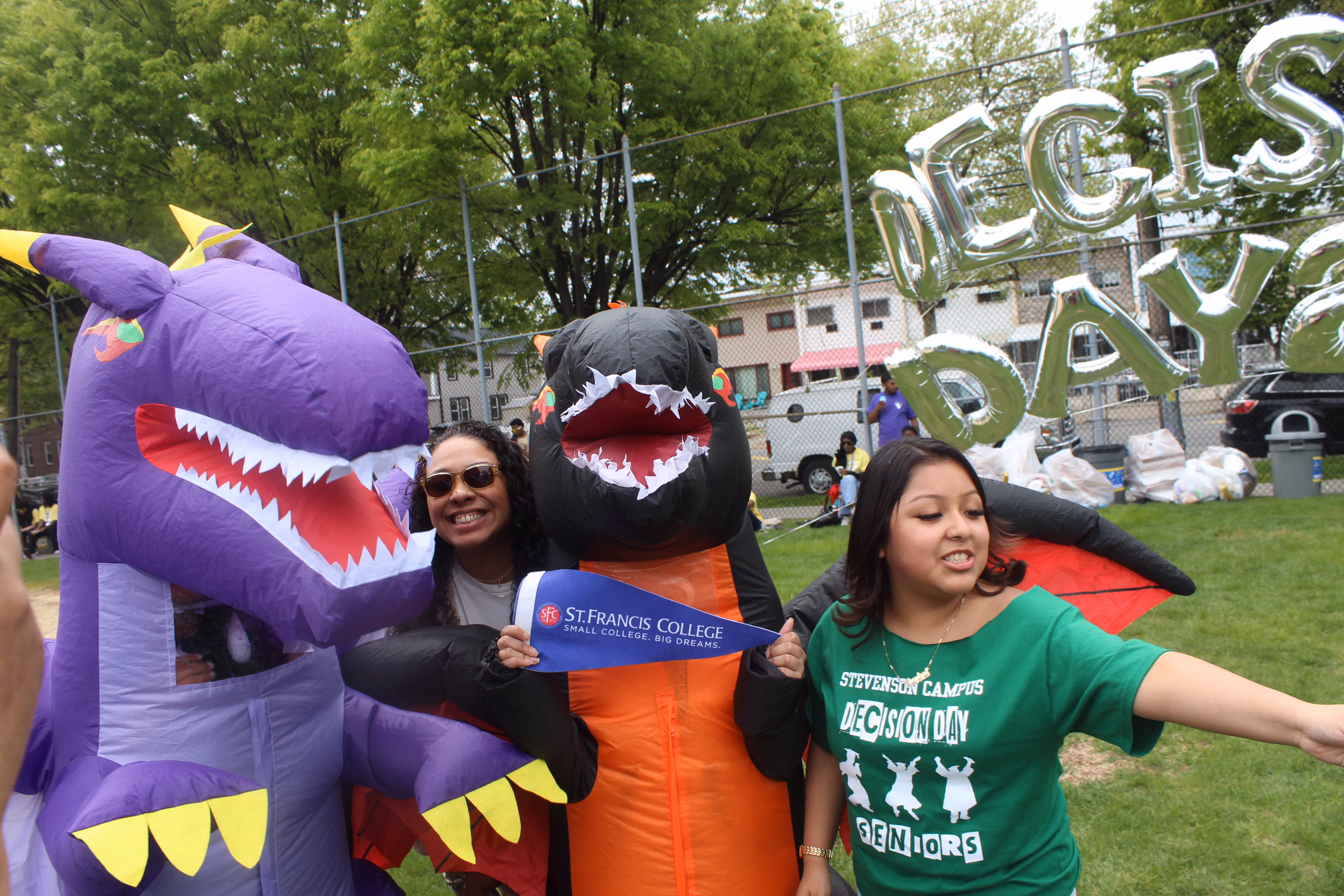 Students posing with mascot costumes at outdoor school event