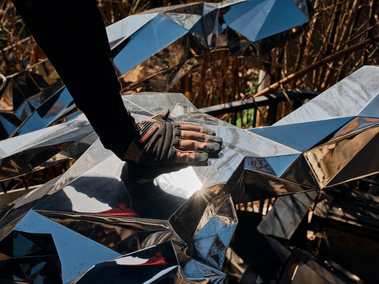 Rivlin places his hand on Benisty’s 15-foot sculpture, “Broken but Together,” which survived the fires at his destroyed home. (Philip Cheung/For The Washington Post)