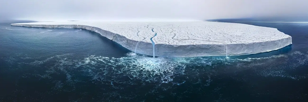 Austfonna Ice Cap by Thomas Vijayan, Canada. The Bråsvellbreen glacier, part of the Austfonna Ice Cap in Svalbard. Early melting and powerful waterfalls reveal the urgent reality of climate change—reminding us what’s at stake if we fail to act.