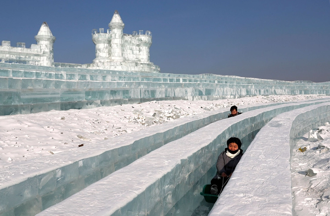 Visitors ride a slide in front of ice sculptures on January 7, 2019. The Atlantic.