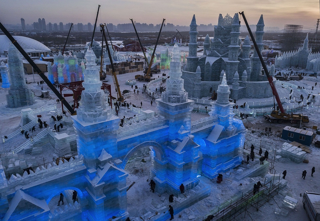 Chinese laborers work to finish large ice sculptures. December 22, 2018. The Atlantic.
