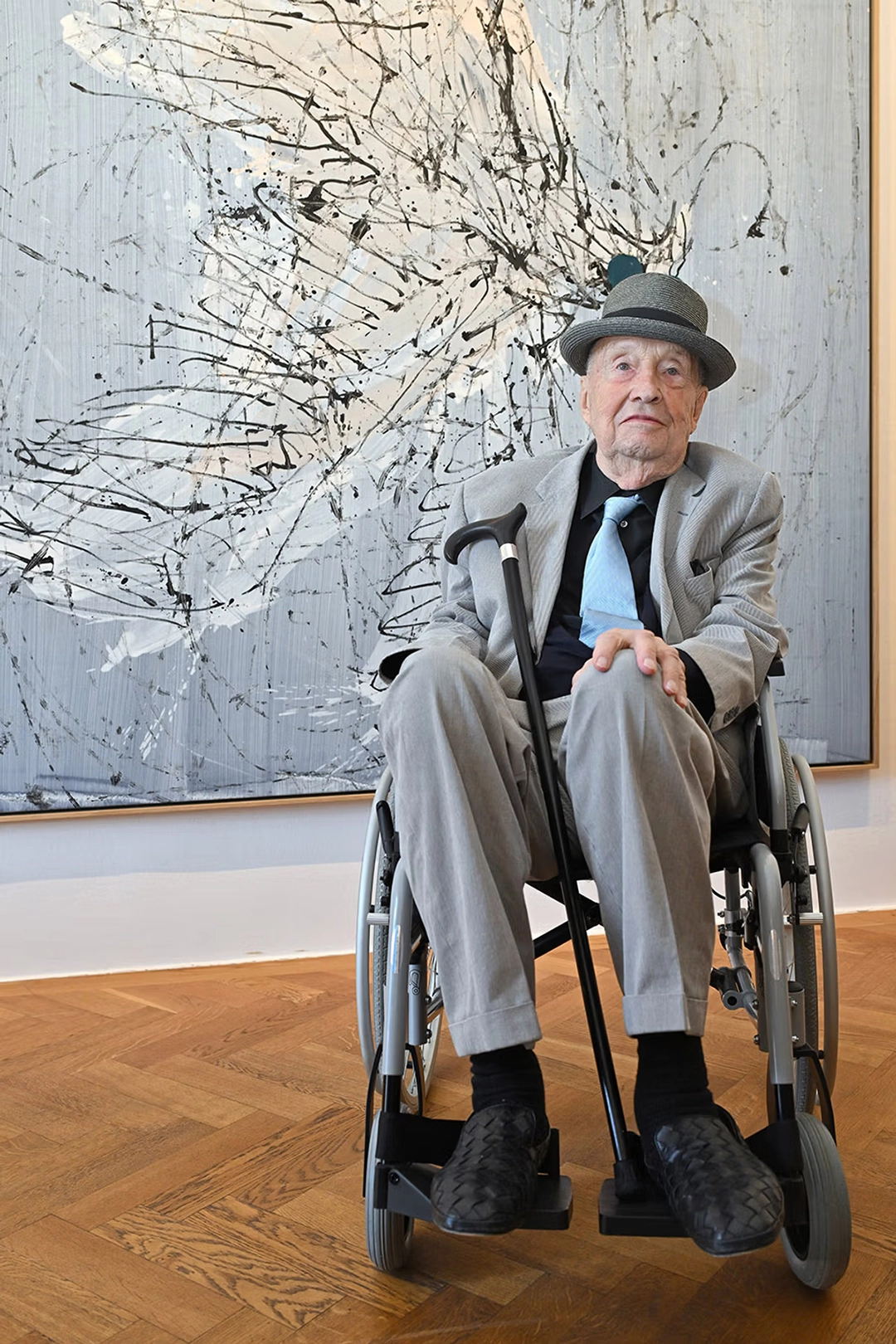 As part of a new process, Baselitz is pulled on a rope across his canvas by an assistant. By Kerstin Joensson / Getty Images.