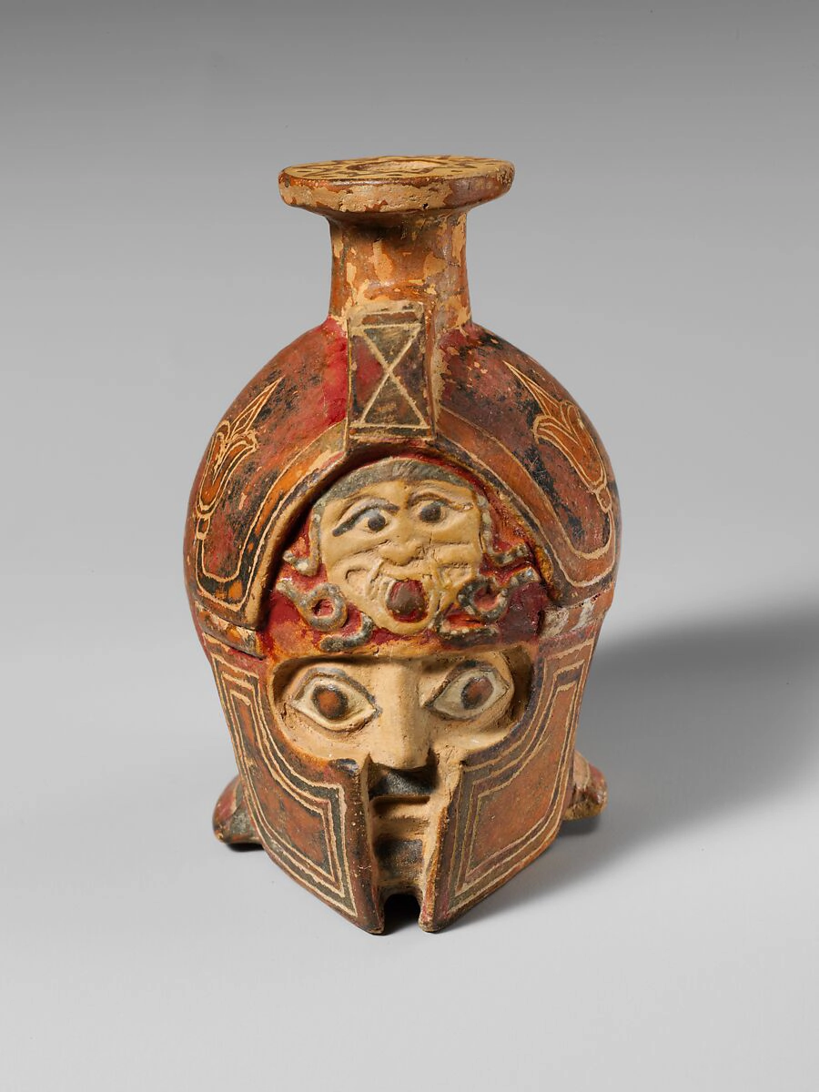 Terracotta aryballos in the form of a warrior’s head, with a gorgoneion on the helmet. East Greek, ca. 600–575 BCE. The Metropolitan Museum of Art, New York.